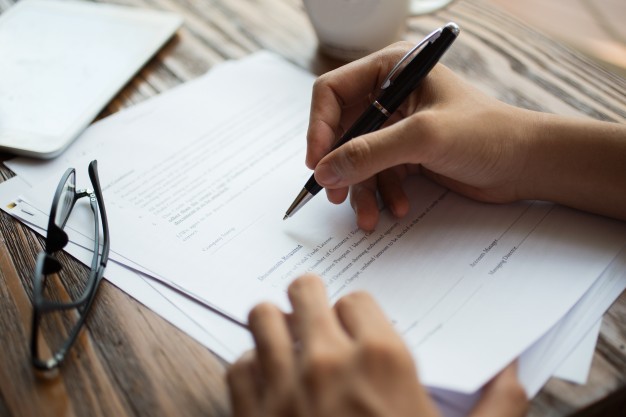 businessman examining papers table 1262 3706